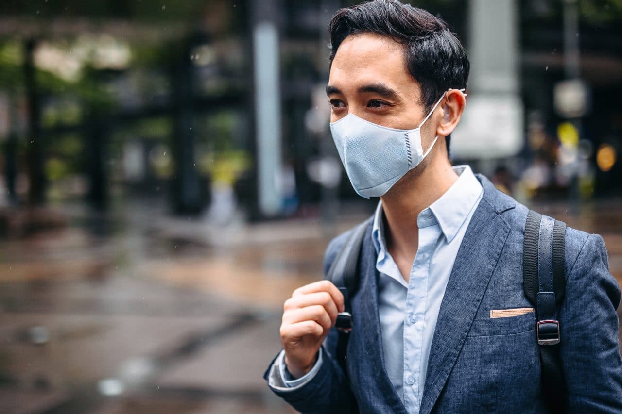 Businessman wearing mask in city