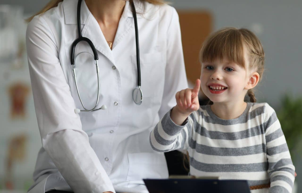 A doctor sits with a girl.