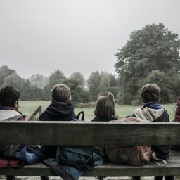 Children sitting together outside on a bench.