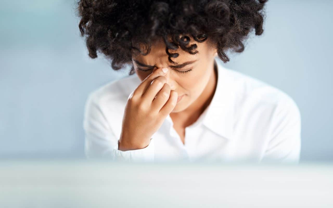 Close-up of a woman experiencing sinus pressure.