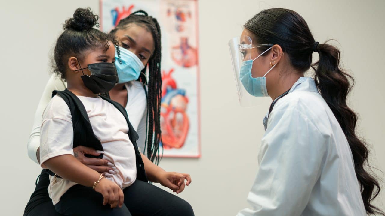 Mom and daughter visiting with an ENT doctor in a clinical setting.