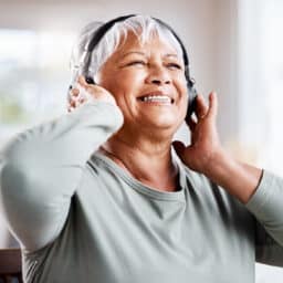 Older woman listening to music with headphones.