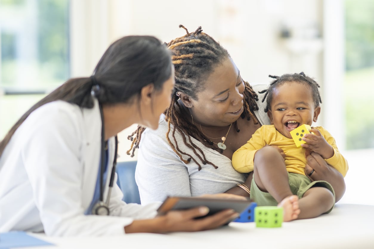 Young boy and mother talking to the doctor at his appointment