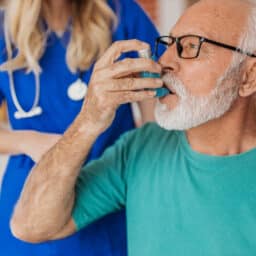 Senior man using an asthma inhaler