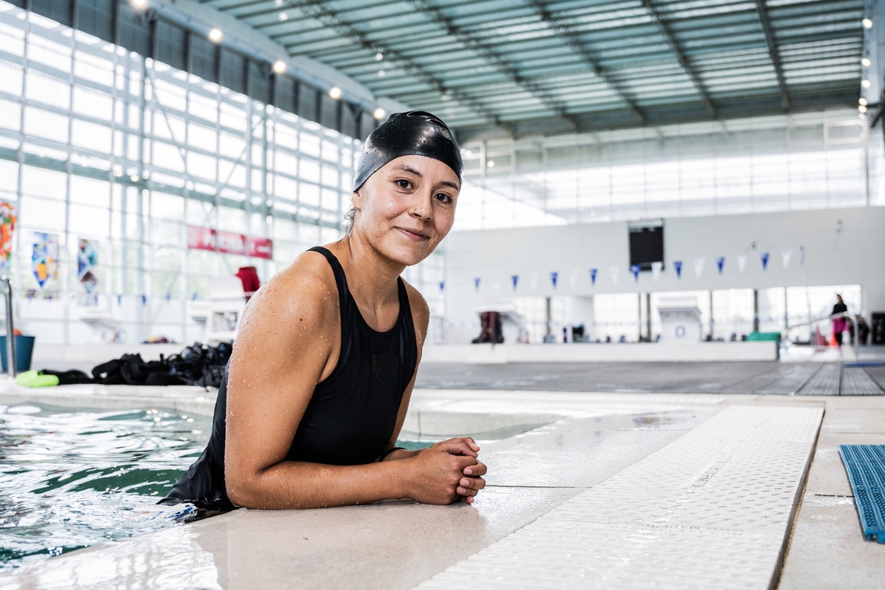 Woman with a swimming cap on in the pool.