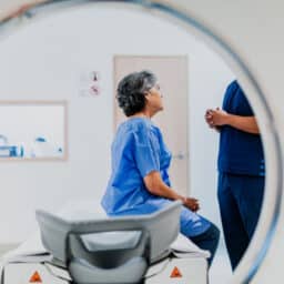 Woman talking to her provider before doing a CT scan.