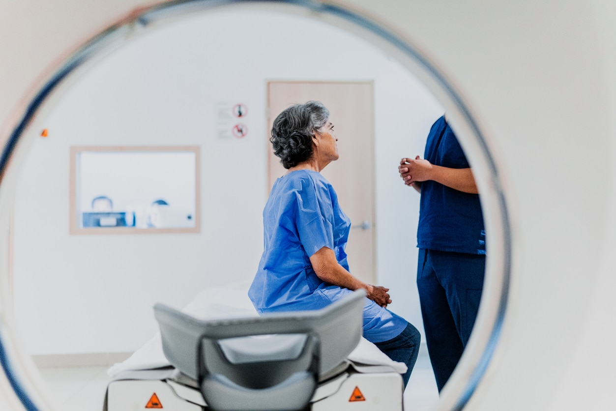 Woman talking to her provider before doing a CT scan.